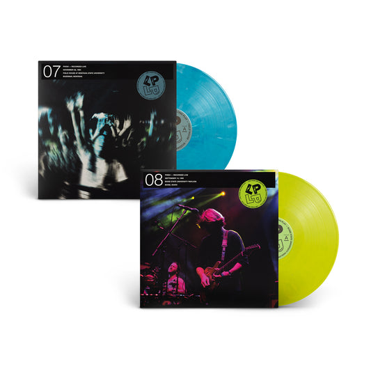 Two LP records with printed album covers displayed on a white background. The set includes a black-and-white concert photo vinyl jacket with a translucent blue record, and a dark purple-toned guitar performance vinyl  jacket with a translucent yellow-green record.